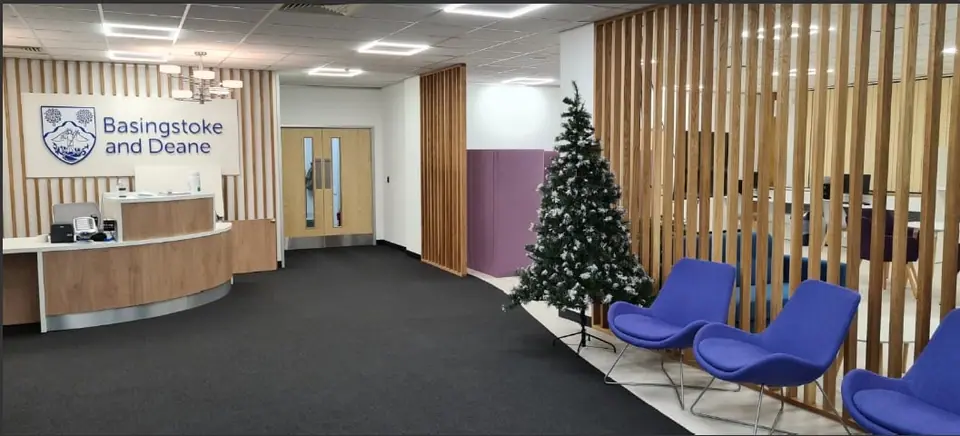 Waiting area with blue lounge chairs beside timber slatted screens