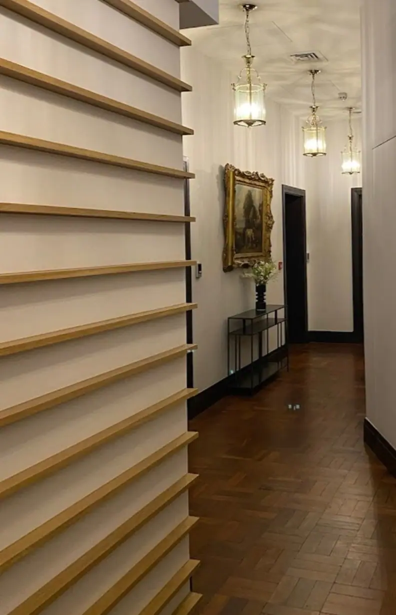 Panelled corridor with timber slats and pendant lights at The Bath House, London