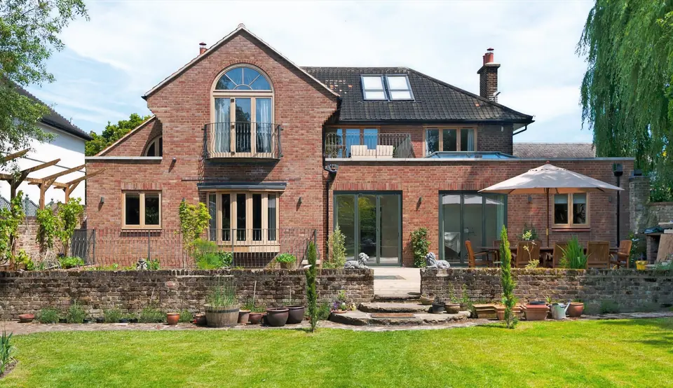 Rear of the renovated Blackheath house with arched window, new dormer and garden terrace