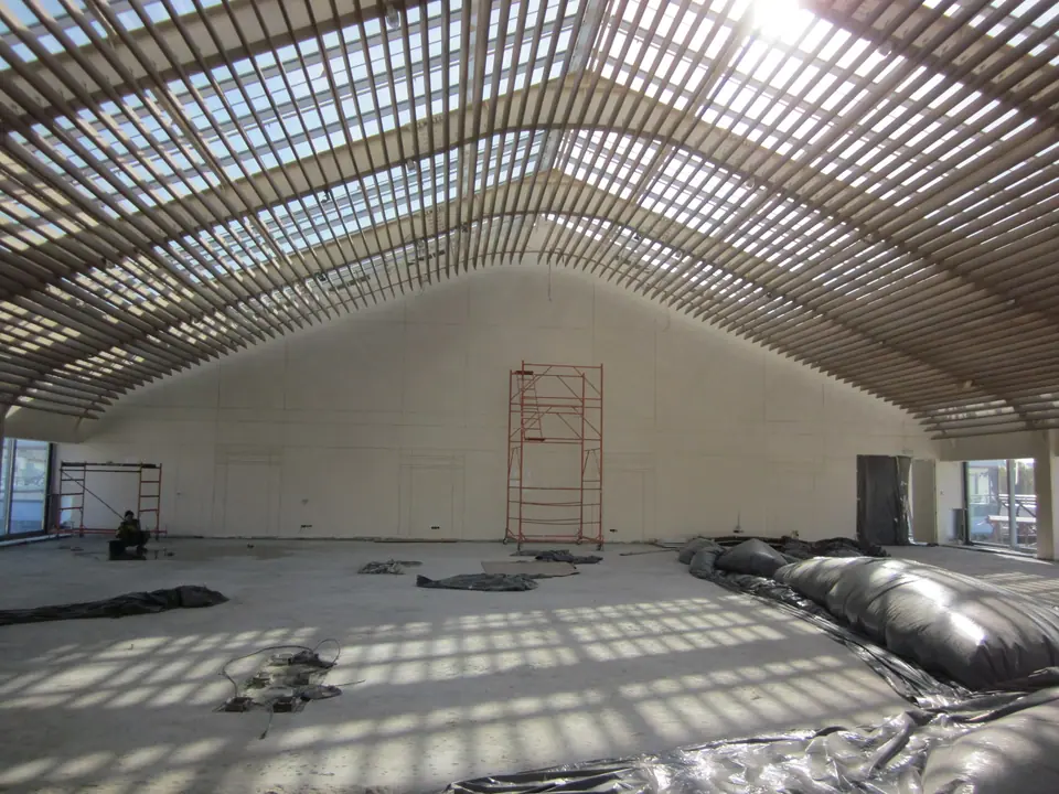 Restaurant interior under construction with timber roof structure and scaffolding