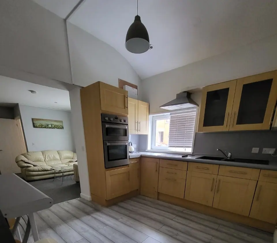 Kitchen with oak-effect units and vaulted ceiling