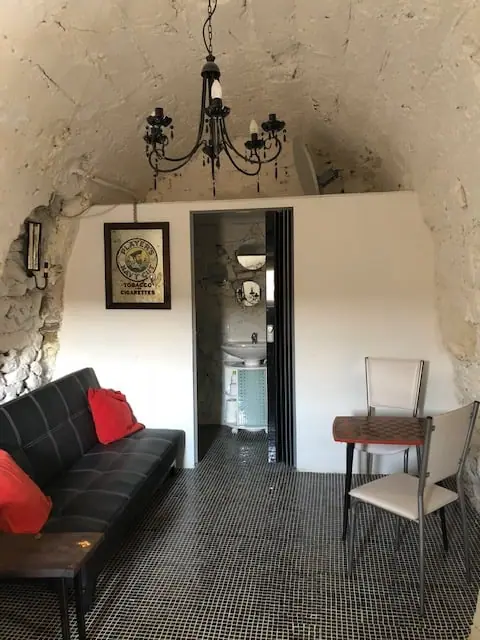 Lounge area with black sofa and red cushions beneath the vaulted ceiling