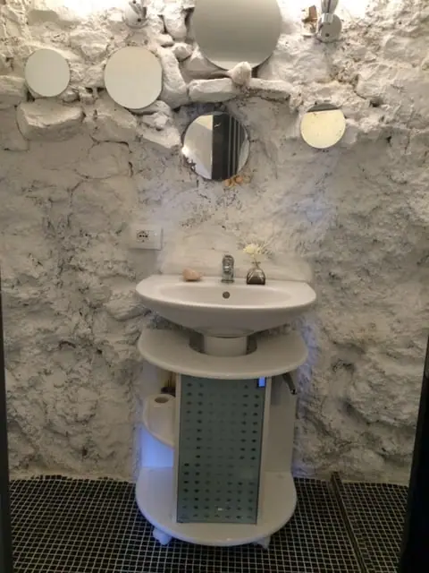 Shower room with exposed stone walls and a pedestal basin