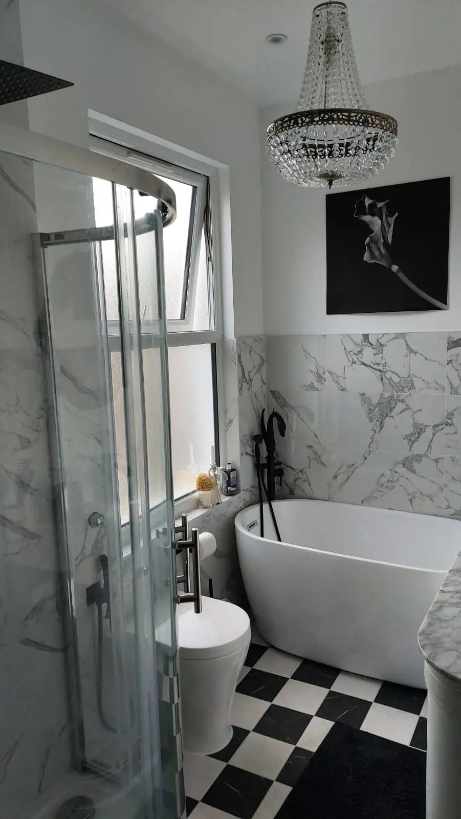Freestanding bath, crystal chandelier and black-and-white chequerboard floor
